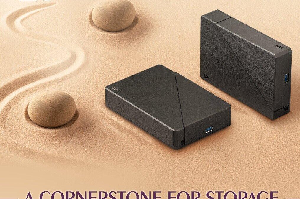 Вид спереди и сбоку внешний жесткий диск Silicon Power Stream S07 черного цвета на песчаном фоне