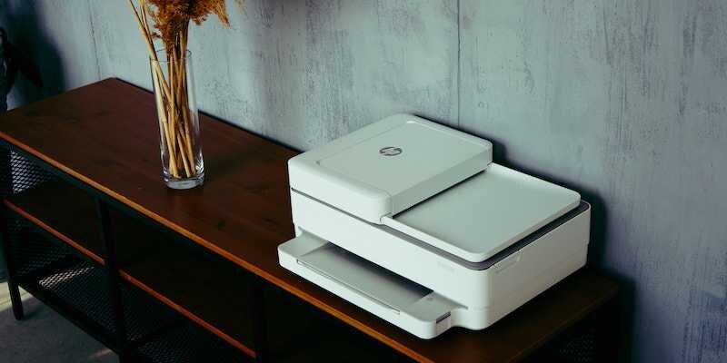 Многофункциональный принтер HP на темном деревянном столе