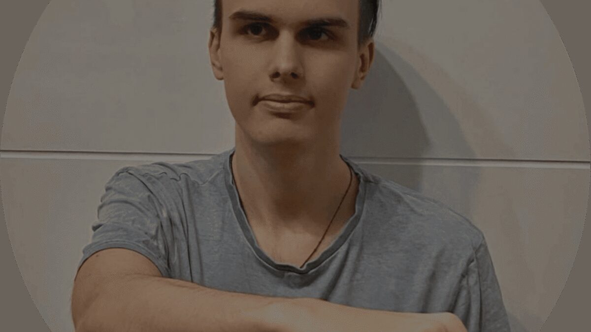 Фигура молодого человека с короткими тёмными волосами на серой футболке на сером фоне